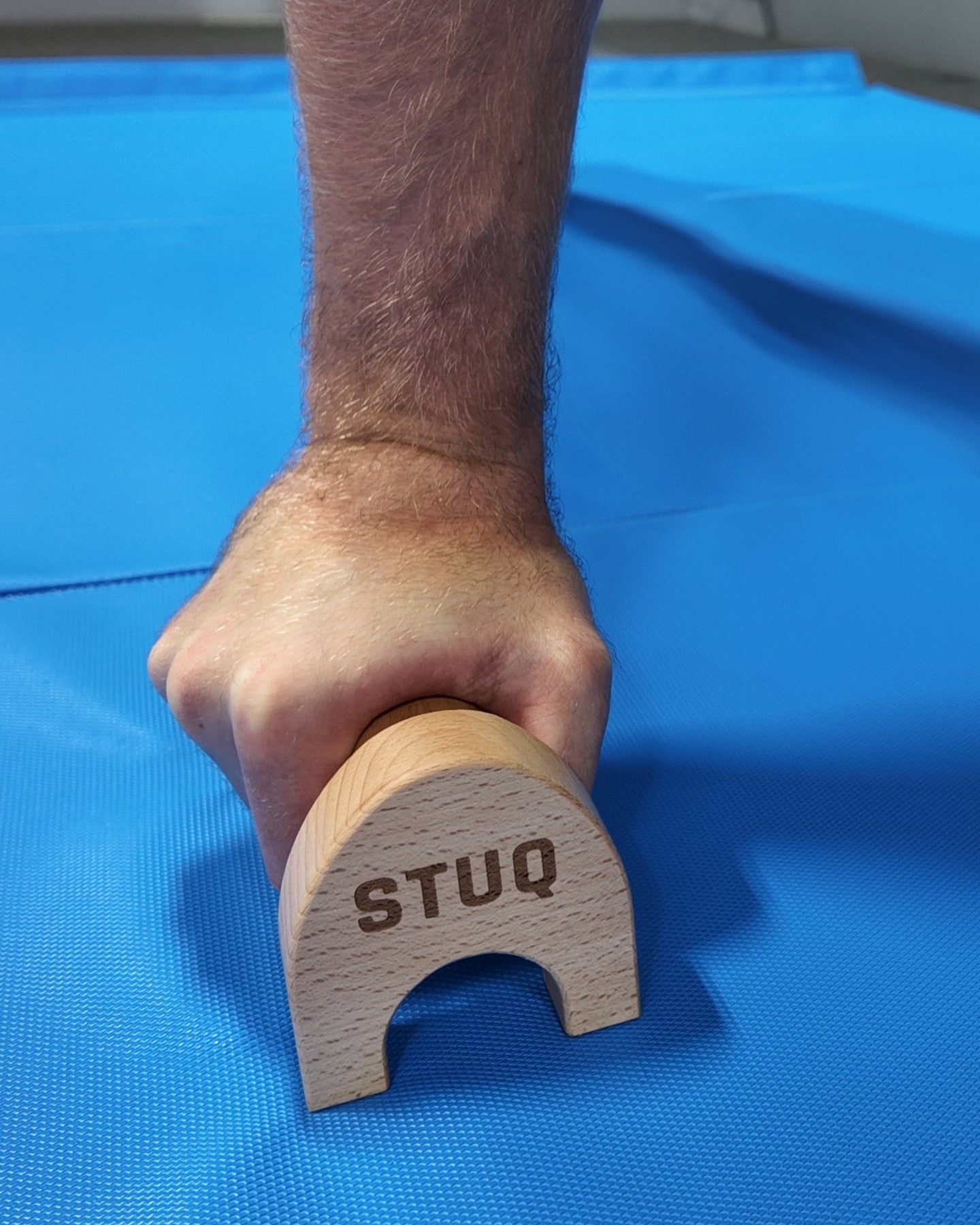 Person using parallette on a blue mat